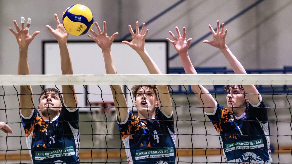 Foto sul campo del muro della squadra di pallavolo Serie C Ilario Ormezzano SAI, tre ragazzi della squadra fanno muro per non far passare la palla