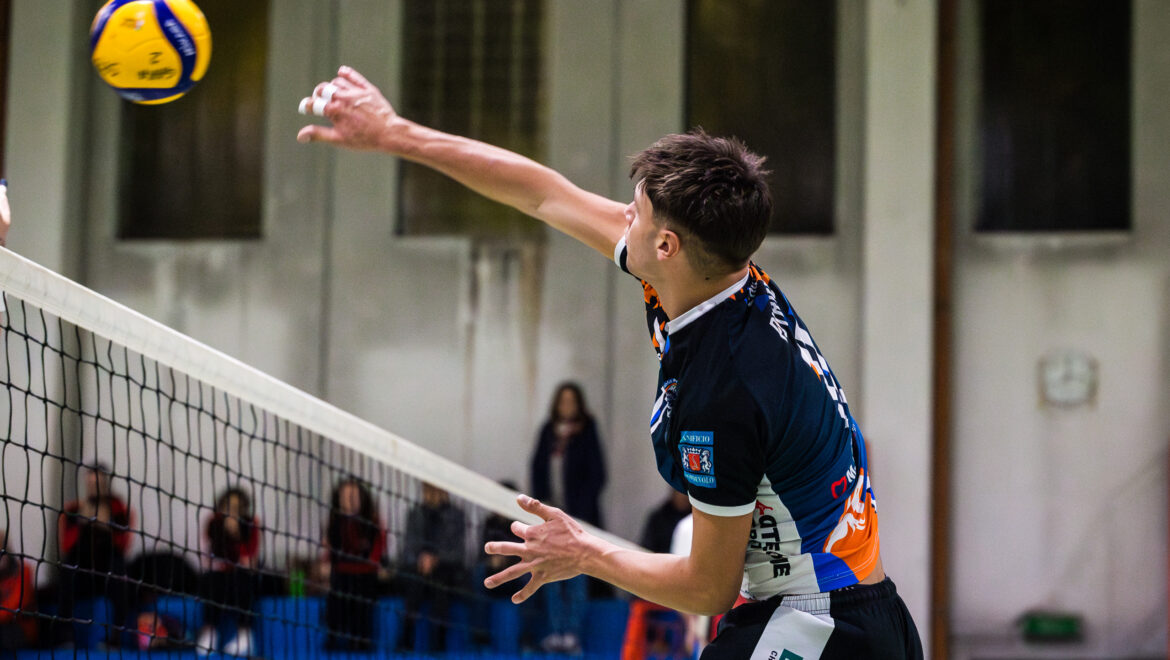 Giovane atleta pallavolista della Serie C Ilario Ormezzano mentre schiaccia sul muro degli avversari